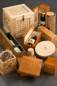 A collection of luxurious wooden wine and food boxes of various shapes and sizes displayed on a dark surface, exuding elegance and sophistication.