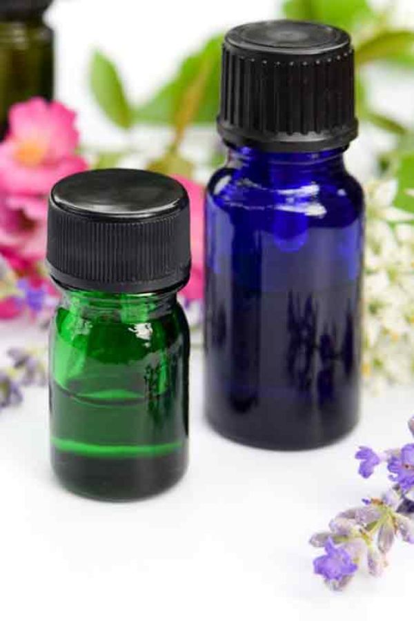 dark coloured glass bottles with flowers on a white background