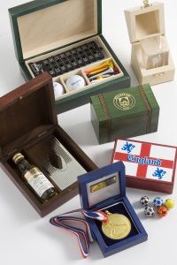A collection of gift boxes including golf balls, a chess set, a liquor bottle, a medal with a ribbon, and a box with "England" and soccer balls.